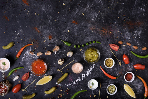 Sauces and dips, ingredients and snack on messy table background. Top view.