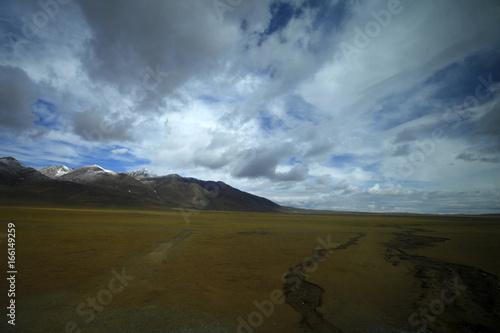 The blue sky white clouds and grassland snow mountain landscape