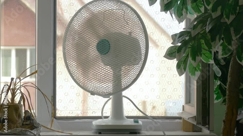 Domestic fan on windowsill in room / Domestic fan on window sill in room in hot days 