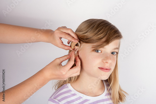 Adorable girl trying a hearing aid