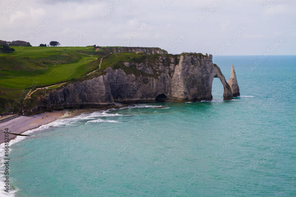 Etretat  chalk cliffs, including three natural arches and a pointed formation called L'Aiguille or the Needle.  Seine-Maritime department, Normandie, in north-western France. April 16th, 2017