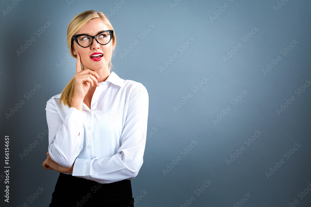Young woman in a thoughtful pose on a gray background Young woman in a thoughtful pose on a gray background