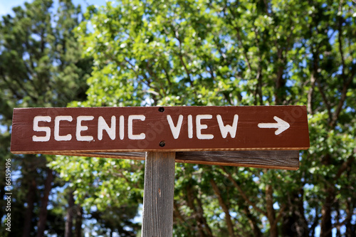 A clear wooden "SCENIC VIEW" sing on a tourist hiking trail 