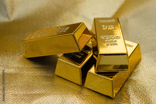 four pieces of gold bars on a golden background