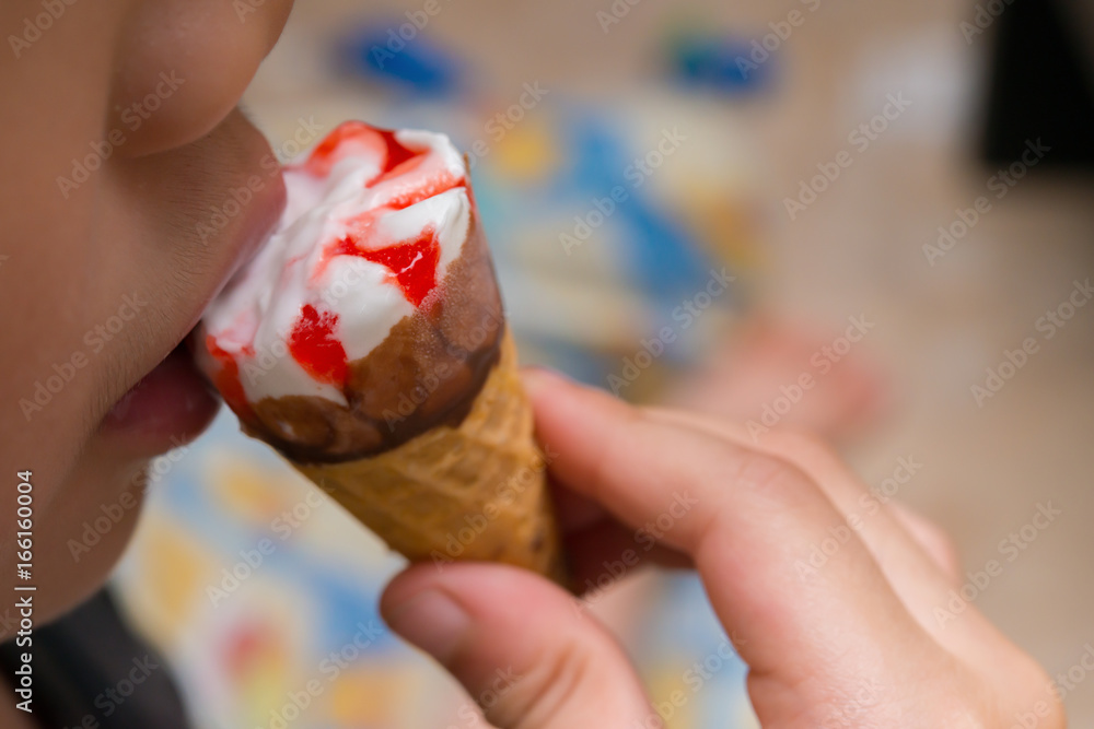 kid eating strawberry flavor ice cream cone at home kid eating strawberry flavor ice cream cone at home