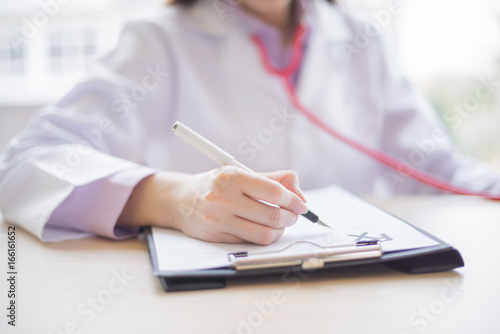 doctor writing prescription in paper to patient