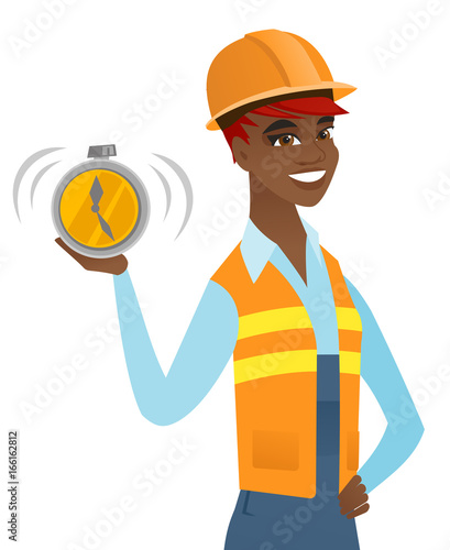 Young african-american builder holding alarm clock
