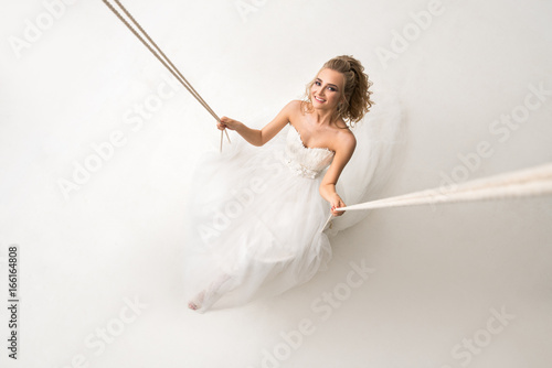 Beautiful bride posing on a swing shot from above photo