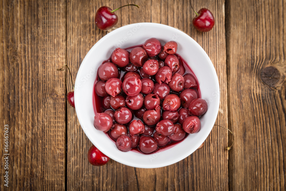 Portion of Canned Cherries on wooden background, selective focus Portion of Canned Cherries on wooden background, selective focus