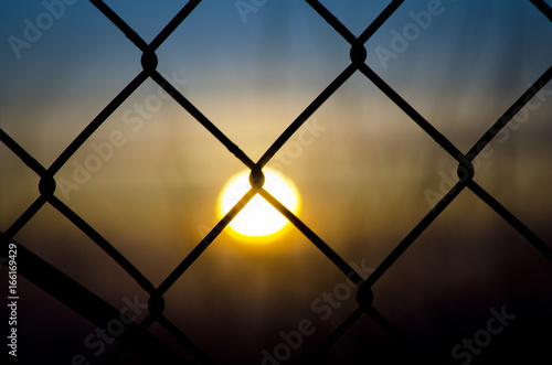 Sun sets behind the fence