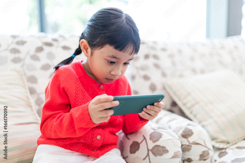 Young little girl playing mobile phone at home Young little girl playing mobile phone at home