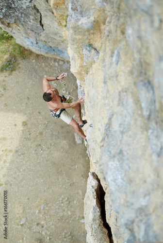 adult man rock climber. rock climber climbs on a rocky wall. man makes hard move