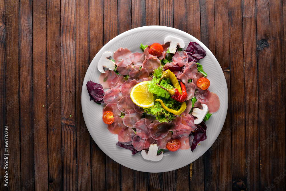 Carpaccio of beef, vegetables, cheese, spices, to Wooden background. Top view. Free space Carpaccio of beef, vegetables, cheese, spices, to Wooden background. Top view. Free space