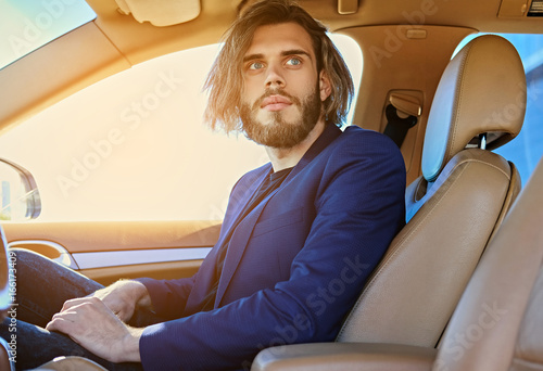 Casual bearded male with long hair in a car. © Fxquadro