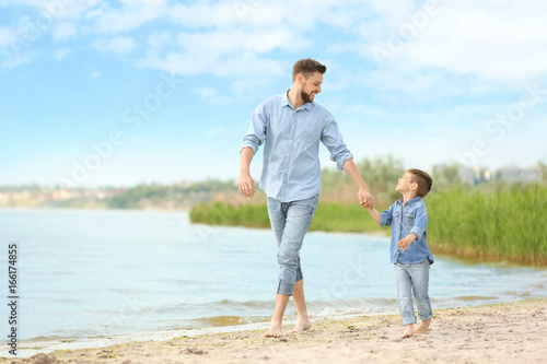 Dad and son walking together on beach