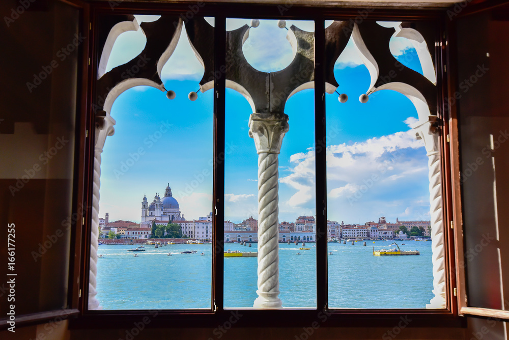 Fototapeta premium Spektakularny widok na Wenecję z typowego weneckiego okna. Miasto przygotowuje się do Redentore. Głównymi tematami są dzwonnica św. Marka, bazylika i kanał Giudecca
