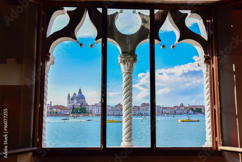 Spectacular view of Venice from a typical Venetian window. The city is preparing for Redentore. Bell tower of Saint Mark, basilica and Giudecca canal are the main subjects