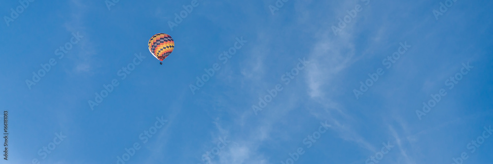 Colorful hot air balloon on bright blue sky