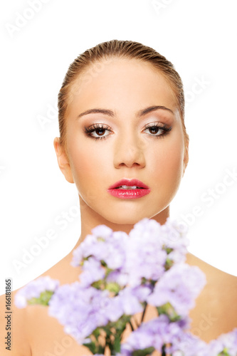 Sensual young spa woman holding flower.