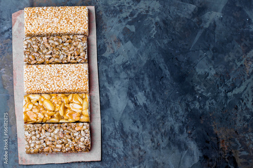 Nuts in caramel, honey on gray table background. Snack food. Uhealthy eating. Copy space,top view photo