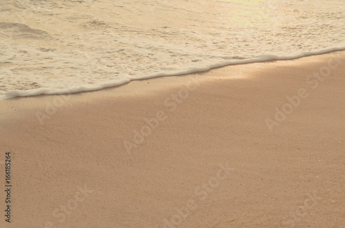 Close up tropical beach with smooth wave and sand texture background.