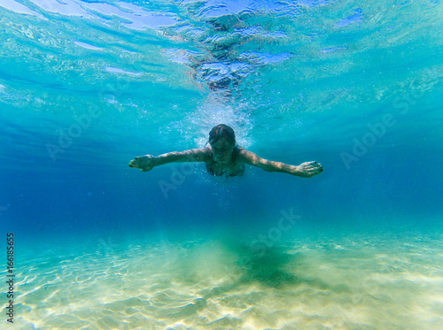 Woman swimming underwater in the sea.