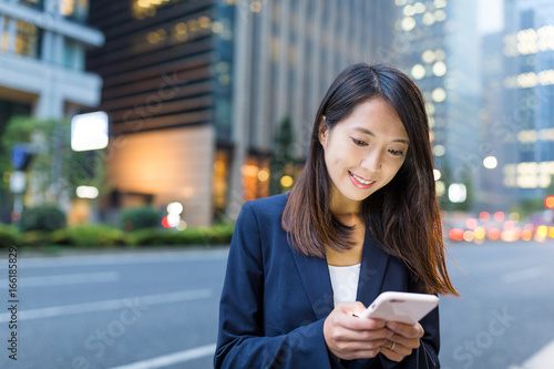 Canvas Print Business woman use of mobile phone in Tokyo city at night