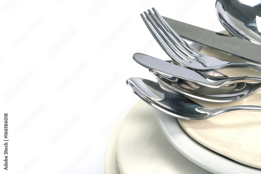 close up the dinning the silverware fork , spoon and knife with dish on white background and text space close up the dinning the silverware fork , spoon and knife with dish on white background and text space