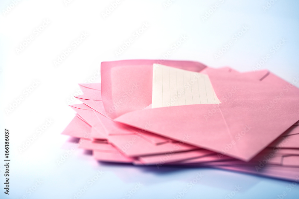 close up Stacking of pink envelopes and mail letter paper on white background close up Stacking of pink envelopes and mail letter paper on white background
