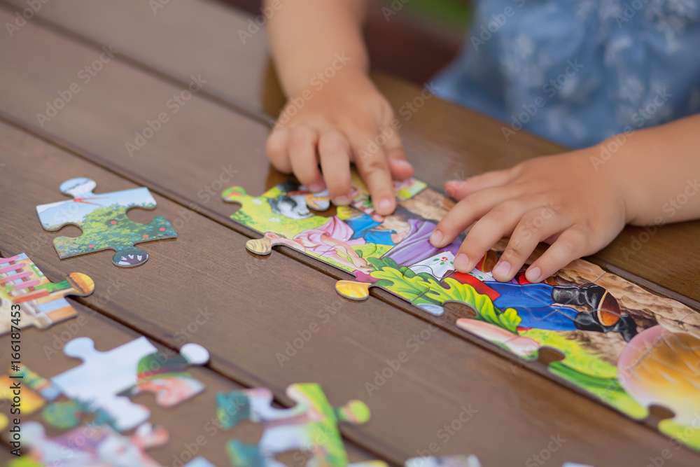 Child playing with puzzle. Child's hands closeup Child playing with puzzle. Child's hands closeup