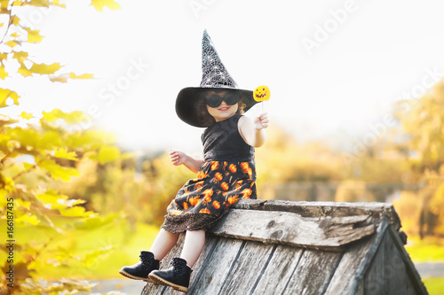 Little girl witch sitting on a roof photo
