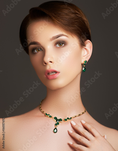Elegant fashionable woman with jewelry. Beautiful woman with emerald necklace. Young beauty model with emerald pendant. Jewellery and accessories. Fashion and beauty salon. Perfect lip makeup