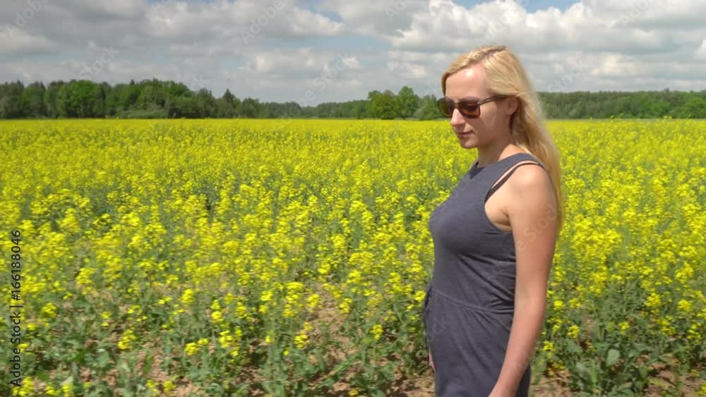 young blonde woman posing in beautiful rapeseed field