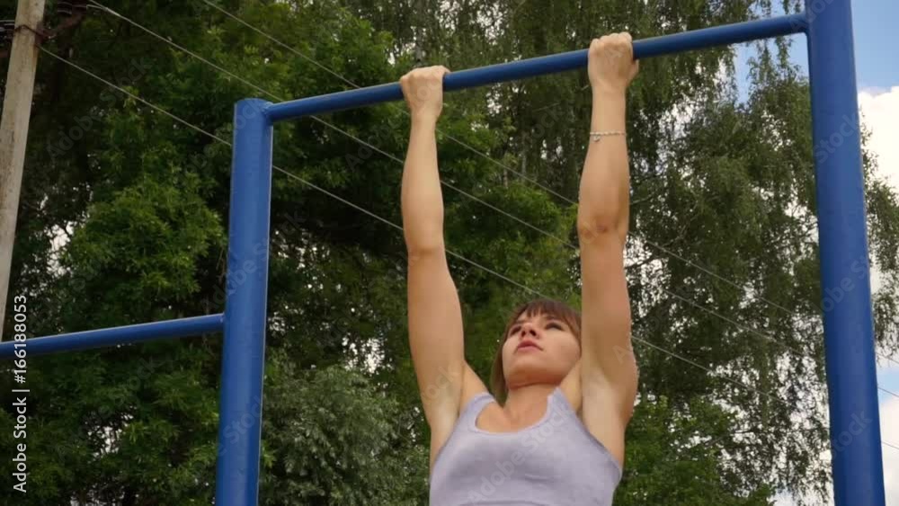 young athletic fitness woman working out at outdoor gym doing pull ups at sunrise young athletic fitness woman working out at outdoor gym doing pull ups at sunrise