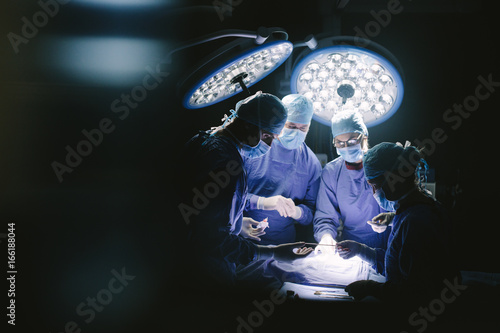 Team of professional surgeons performing surgery photo