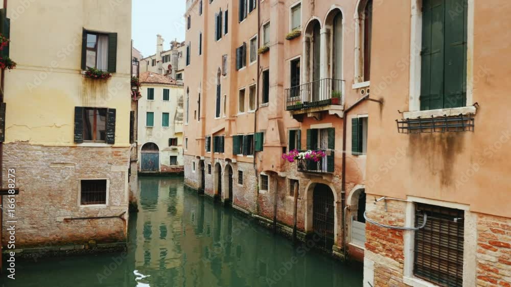 Old buildings and a narrow canal for boats and gondolas in Venice. A typical example of the architecture of Venice Old buildings and a narrow canal for boats and gondolas in Venice. A typical example of the architecture of Venice