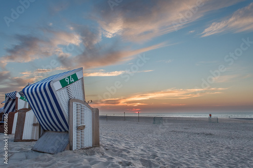 Beach chair in the sunset on the island of Norderney in the German North Sea photo