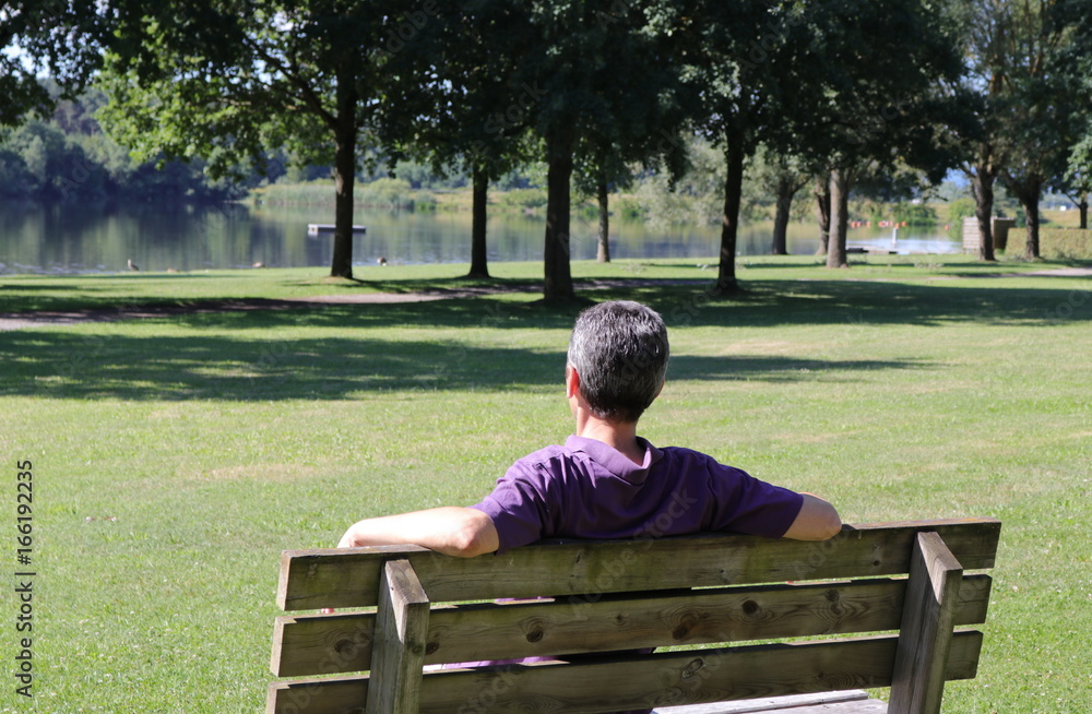 Fototapeta premium Mann sitzt entspannt am See