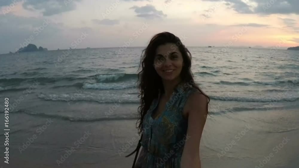 Young Woman Walking On Beach Holding Man Hand At Sunset Action Camera Point Of Vew Of Happy Smiling Girl On Seaside, Couple During Summer Vacation Young Woman Walking On Beach Holding Man Hand At Sunset Action Camera Point Of Vew Of Happy Smiling Girl On Seaside, Couple During Summer Vacation