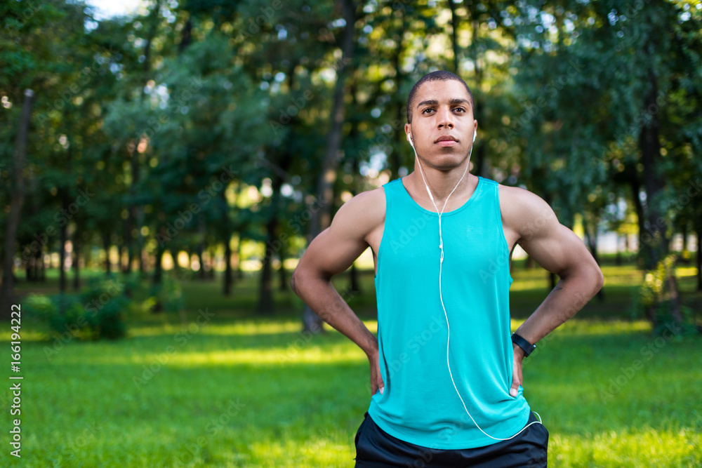 african american sportsman stretching in park african american sportsman stretching in park