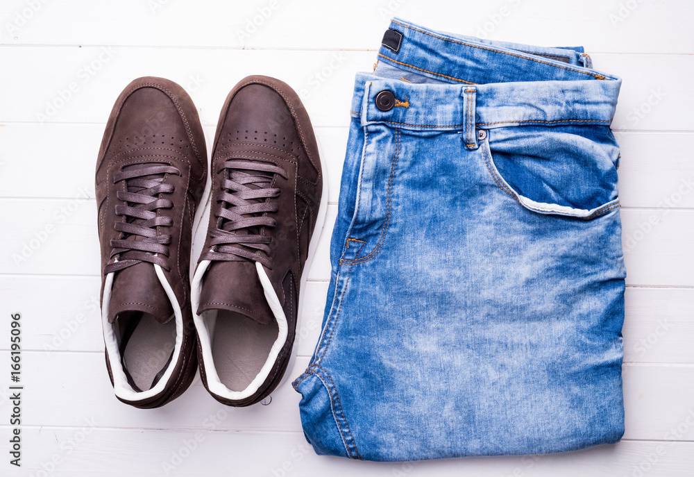 new male shoes and jeans on wooden table, top view new male shoes and jeans on wooden table, top view