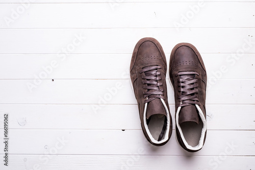 brown leather shoes with laces on wooden background with empty text space