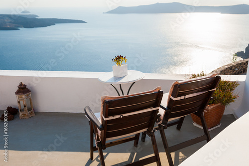Two chairs on the terrace  sea view. Santorini island  Greece. Travel and vacation