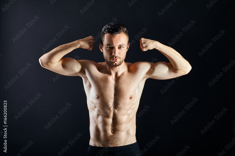 Sexy muscular shirtless man against dark background
