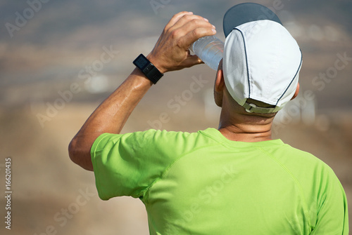 Foto Athletic sport man drinking water from a bottle