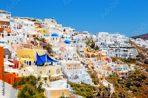picturesque village and the rest in the traditional white houses in Oia, Santorini, Greece