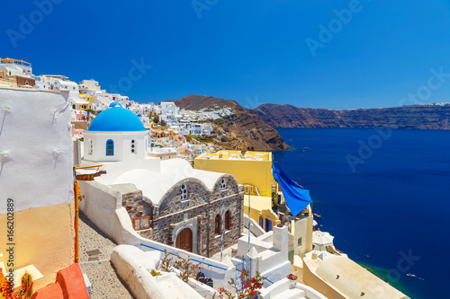 Greece Santorini island in Cyclades, traditional sights of colorful and white washed walk paths like narrow streets and caldera sea in background © vladimircaribb