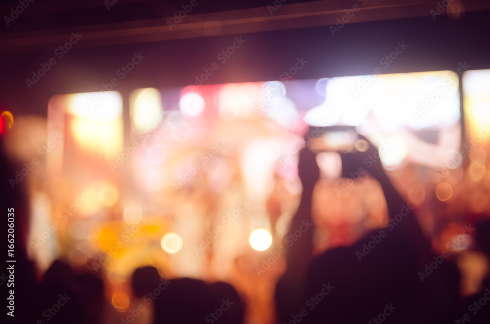 Fototapeta premium Blur people taking smart phone in night outdoor concert with colorful bokeh abstract background.