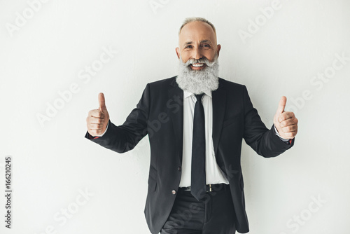 happy senior businessman showing thumbs up on white background