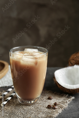 Glass of cold tasty coconut coffee on table